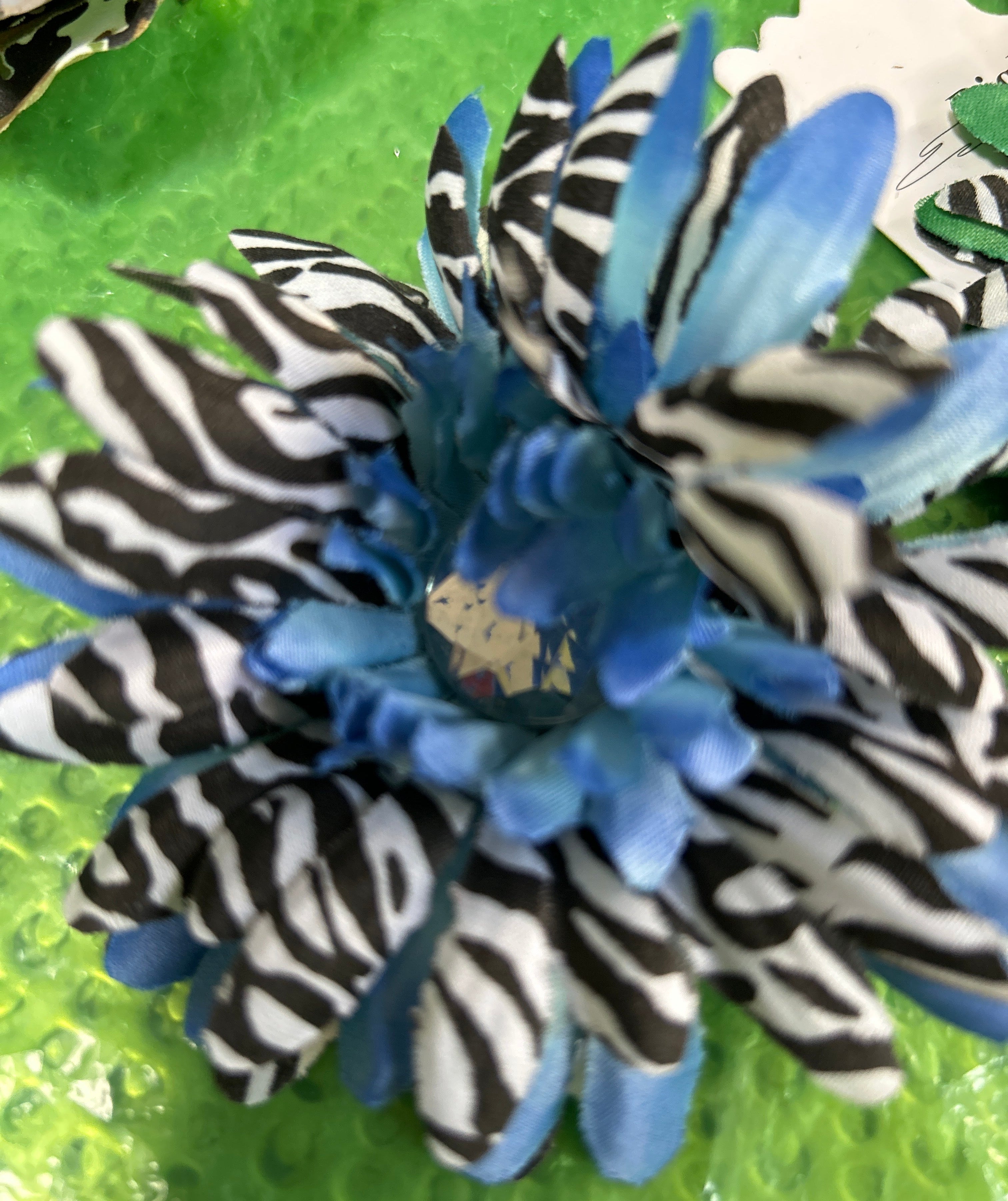 Blue and zebra-patterned flower-like object on a green background