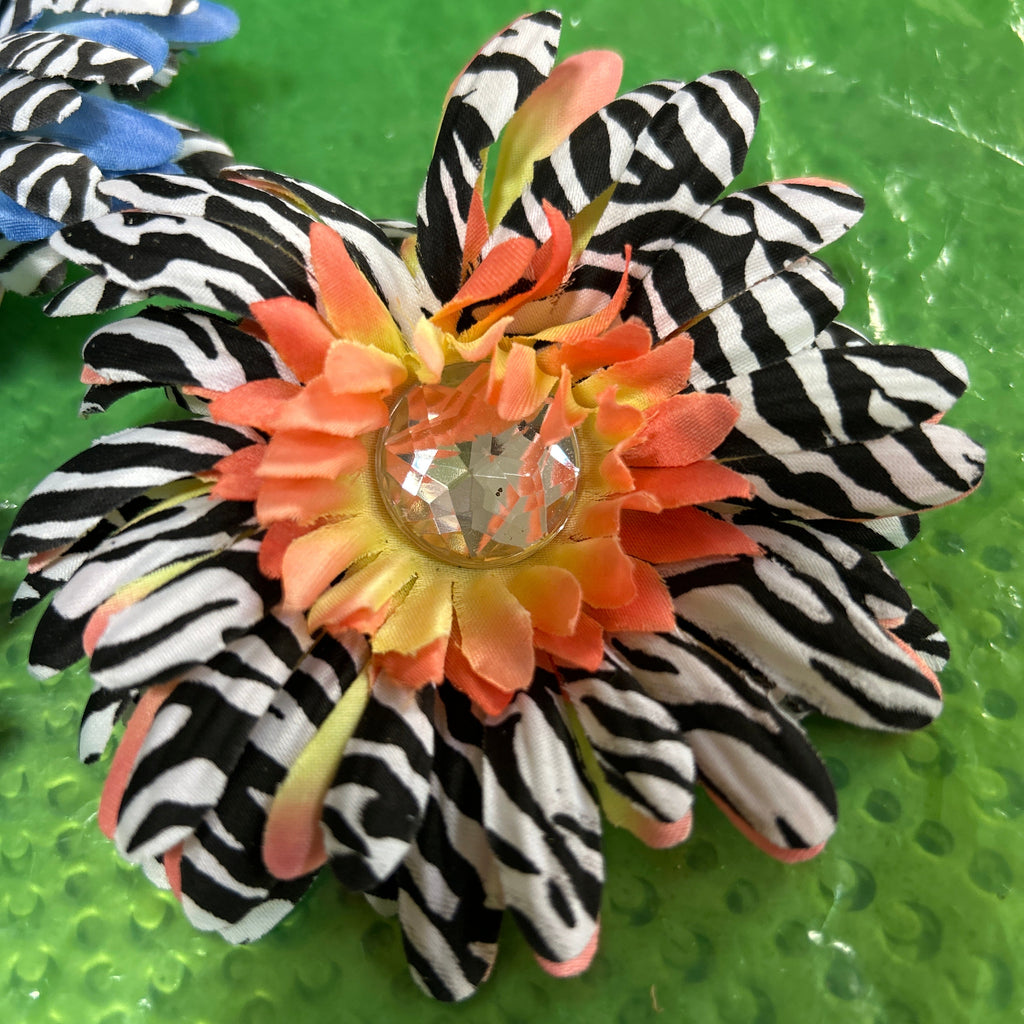 Hair clip with zebra pattern and orange flower on a green background